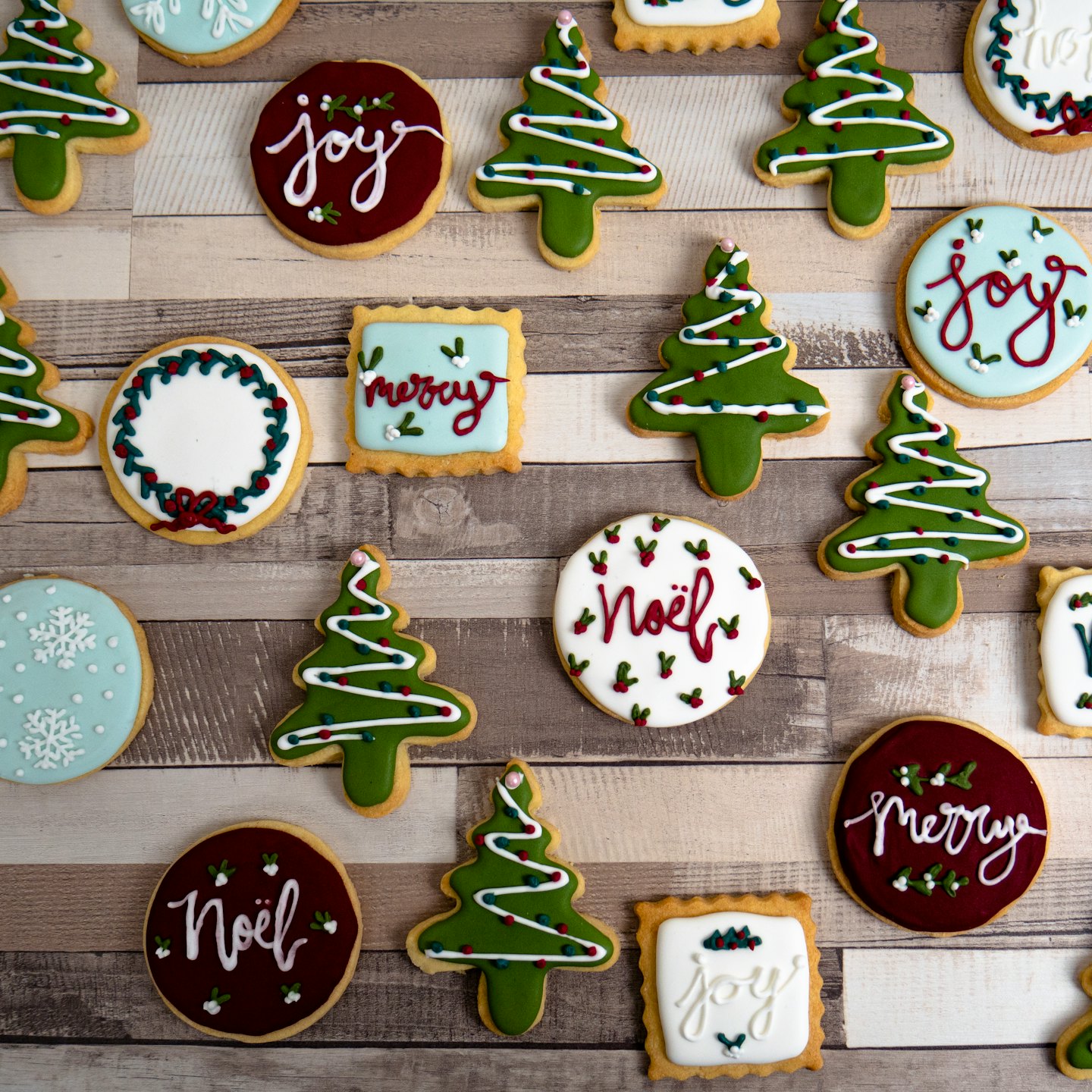 Festive Christmas sugar cookies arranged on a wooden board.