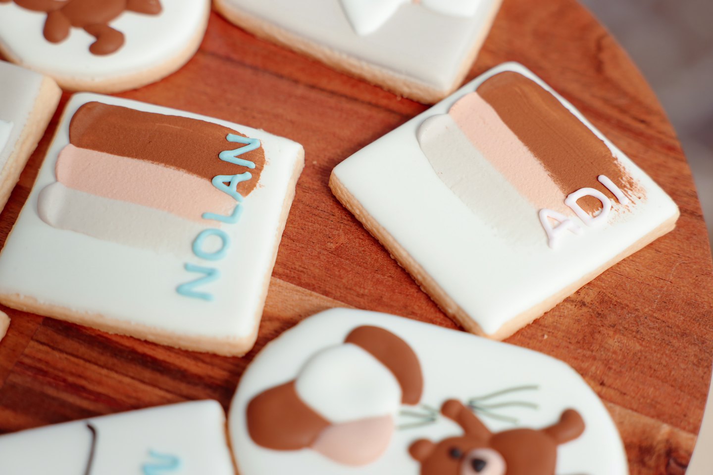 Custom decorated sugar cookies arranged on a wooden table.